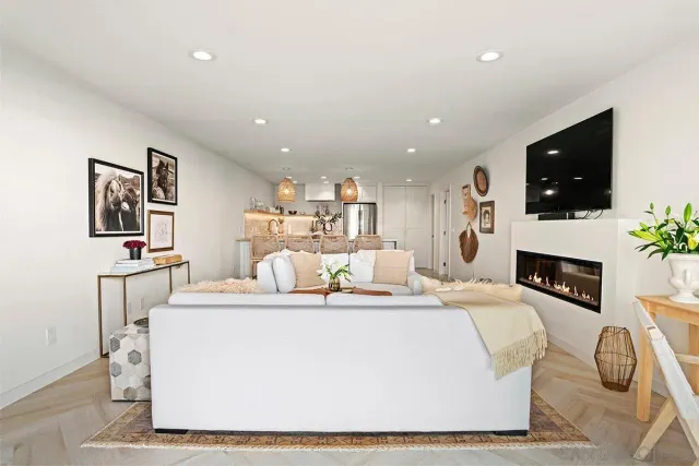 a living room with furniture a flat screen tv and a fireplace