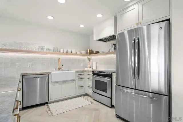 a kitchen with stainless steel appliances a refrigerator sink and stove