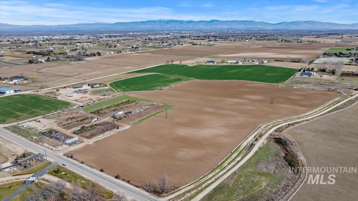 3850 South Black Cat Road Meridian, ID 83642 - Photo 2 of 7 Aerial overview of property's location featuring rural landscape and a mountain backdrop