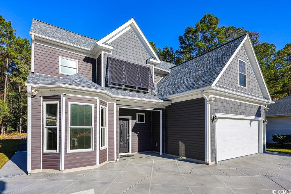 105 Rocko Drive Myrtle Beach, SC 29579 - Photo 2 of 38 View of front facade featuring concrete driveway, a shingled roof, a patio area, and an attached garage