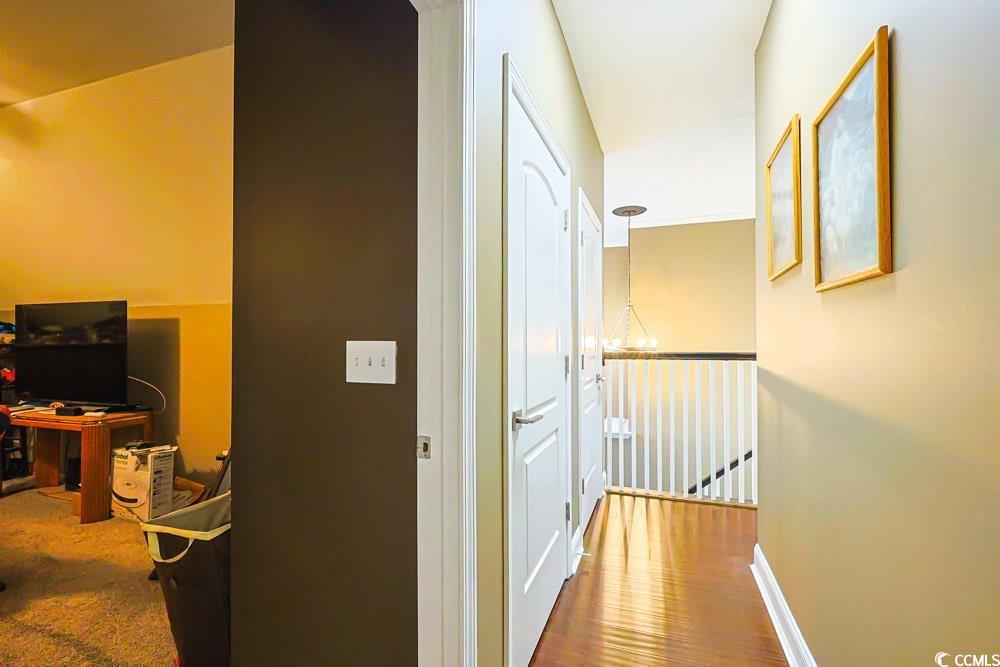 105 Rocko Drive Myrtle Beach, SC 29579 - Photo 26 of 38 Hallway featuring wood finished floors, an office area, and a chandelier