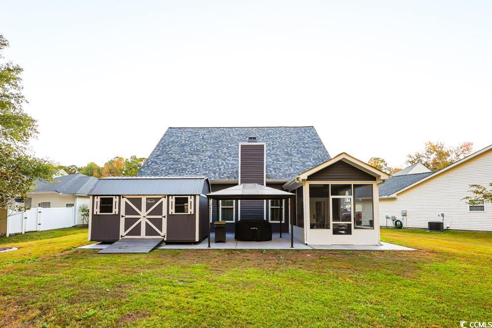 105 Rocko Drive Myrtle Beach, SC 29579 - Photo 33 of 38 Rear view of property featuring a patio area, a storage unit, and a sunroom