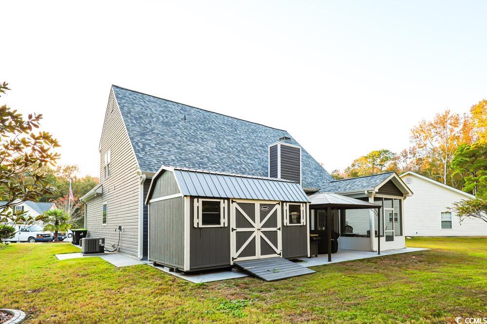 105 Rocko Drive Myrtle Beach, SC 29579 - Photo 34 of 38 Back of property featuring a yard, a shed, roof with shingles, and a patio area