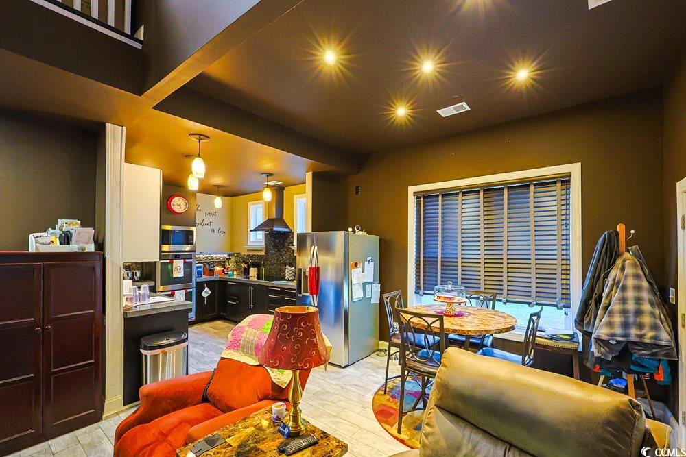 105 Rocko Drive Myrtle Beach, SC 29579 - Photo 6 of 38 Kitchen with backsplash, appliances with stainless steel finishes, wall chimney exhaust hood, and light wood-style floors