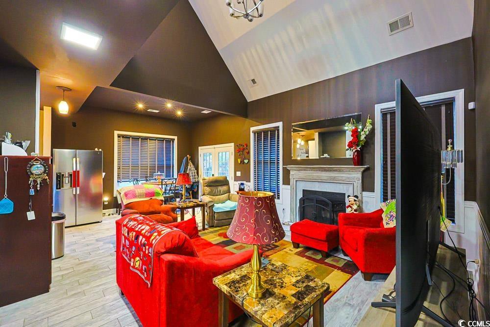 105 Rocko Drive Myrtle Beach, SC 29579 - Photo 8 of 38 Living room with a fireplace, light wood-style flooring, high vaulted ceiling, and a chandelier