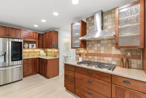 a kitchen with granite countertop a sink stainless steel appliances and cabinets