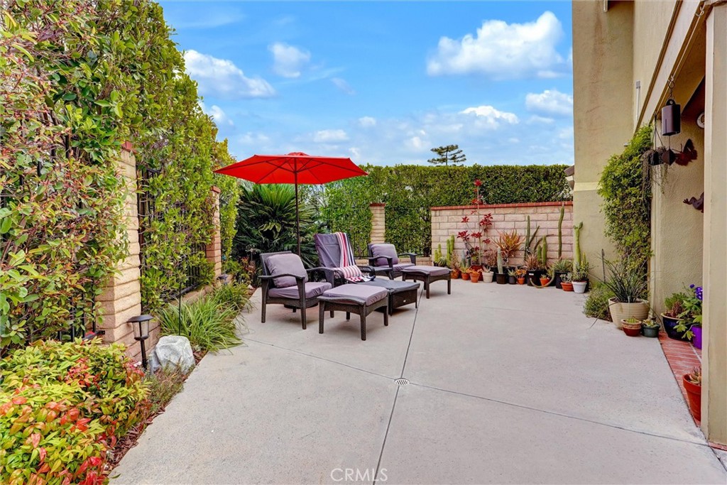 19238 Castlebay Lane Porter Ranch, CA 91326 - Photo 32 of 38 a view of a patio with couches table and chairs under an umbrella with a fire pit