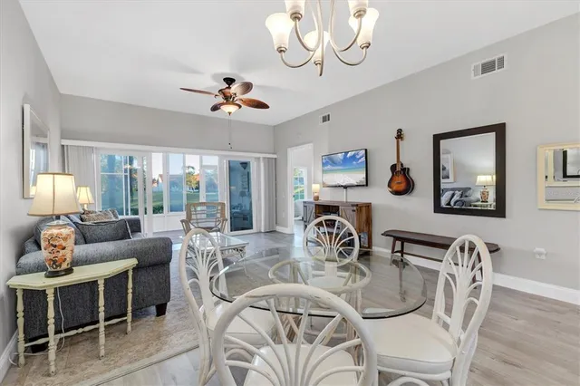 a view of a dining room with furniture a chandelier and wooden floor