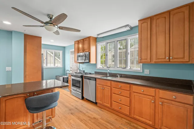 a kitchen with stainless steel appliances granite countertop wooden cabinets a dining table and chairs