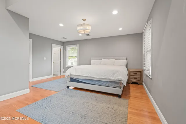a spacious bedroom with a bed and wooden floor
