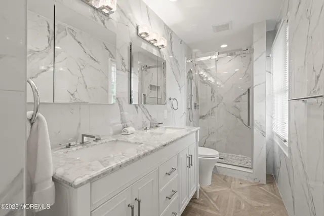 a bathroom with a granite countertop sink toilet and shower