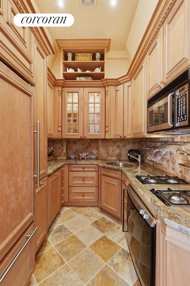 253 West 73rd Street, Unit 5F Manhattan, NY 10023 - Photo 18 of 19 a kitchen with stainless steel appliances granite countertop a stove sink and cabinets