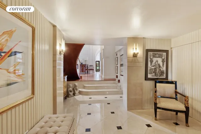 a view of a hallway to a livingroom with furniture and windows