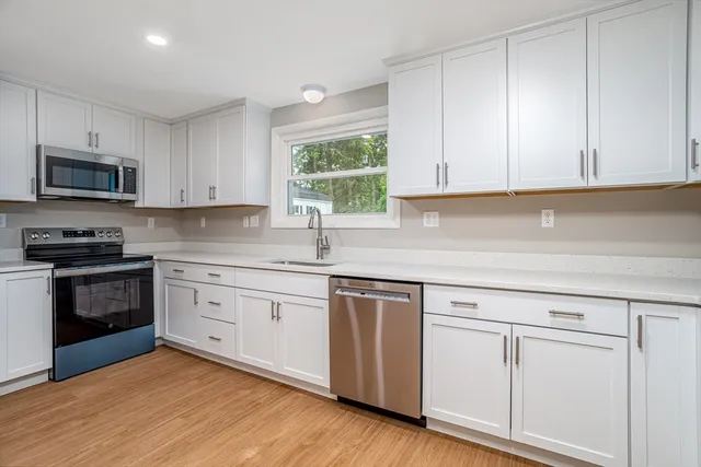 a kitchen with white cabinets and appliances