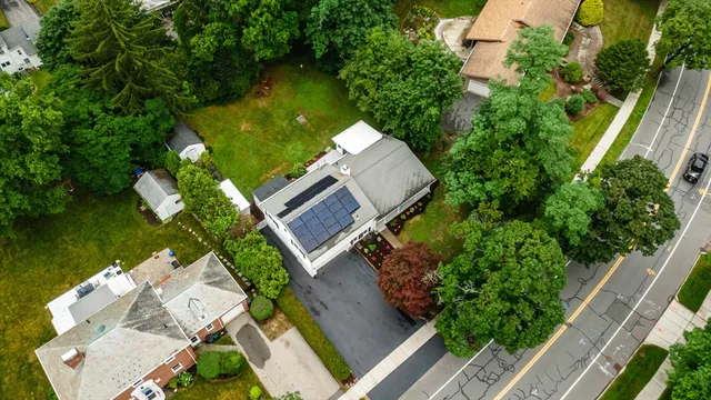 an aerial view of a house with swimming pool and outdoor seating