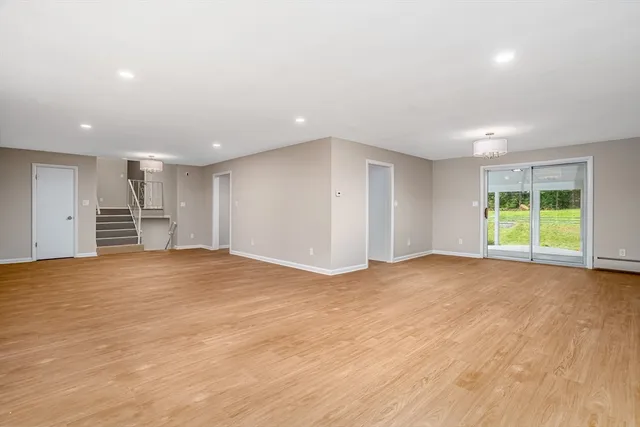 a view of empty room with wooden floor and windows