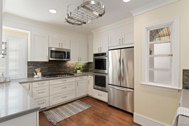 a kitchen with stainless steel appliances a refrigerator sink and microwave