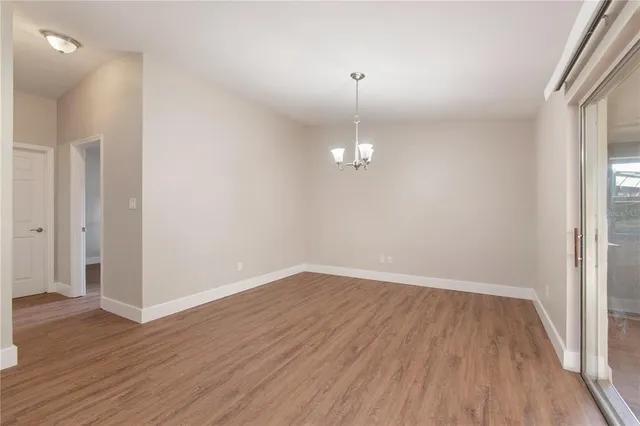 an empty room with wooden floor and door