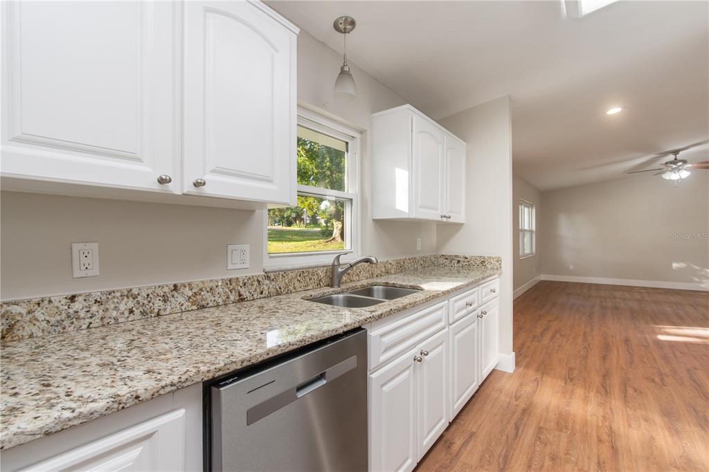 304 Barclay Avenue Altamonte Springs, FL 32701 - Photo 19 of 29 a kitchen with granite countertop white cabinets and a wooden floor