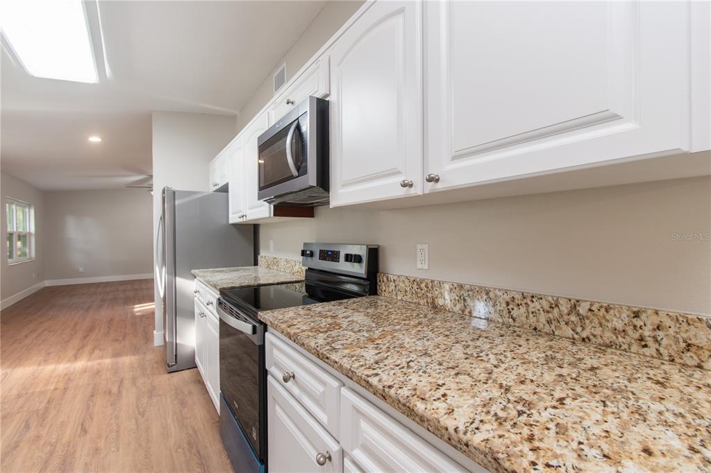304 Barclay Avenue Altamonte Springs, FL 32701 - Photo 23 of 29 a kitchen with stainless steel appliances granite countertop a sink stove and refrigerator