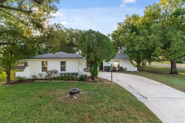 a front view of a house with a yard and trees