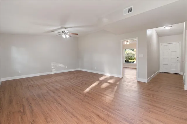 a view of empty room with wooden floor