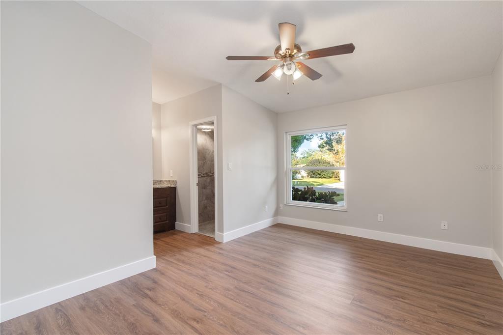 304 Barclay Avenue Altamonte Springs, FL 32701 - Photo 9 of 29 an empty room with wooden floor chandelier fan and windows
