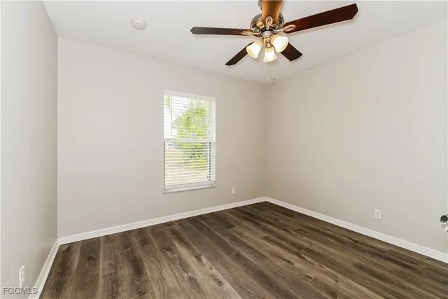 an empty room with a window and a ceiling fan