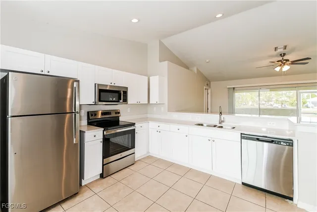 a kitchen with white cabinets and stainless steel appliances