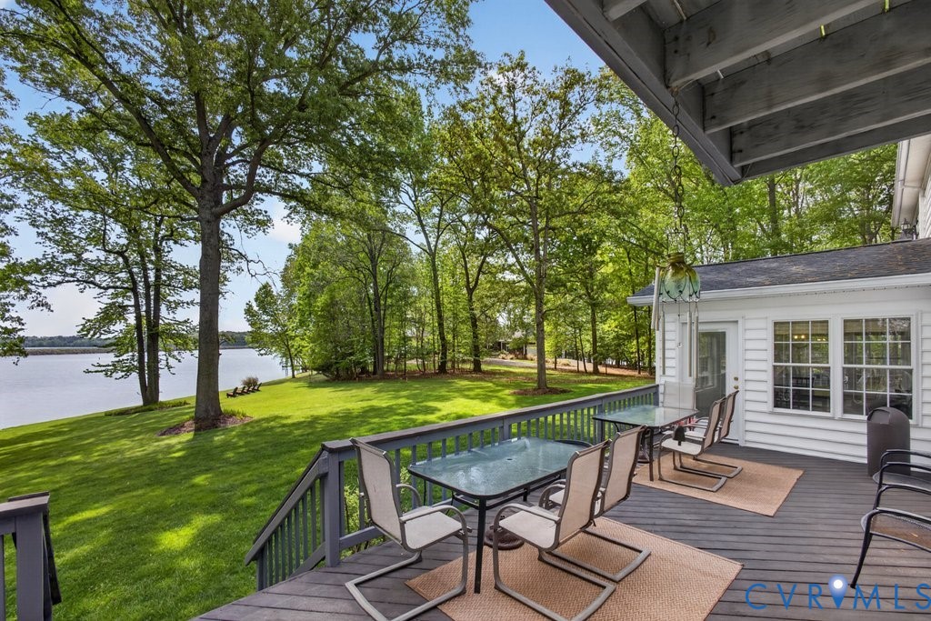 173 Covenant Way Bumpass, VA 23024 - Photo 40 of 55 a view of a backyard with table and chairs under an umbrella with large trees