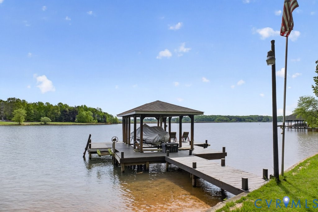 173 Covenant Way Bumpass, VA 23024 - Photo 49 of 55 a view of a lake with couches chairs and wooden floor