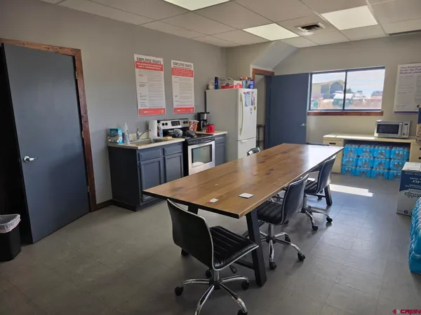 a kitchen with a table chairs and refrigerator