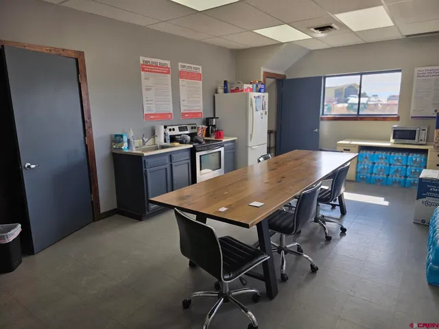 a kitchen with a table chairs and refrigerator