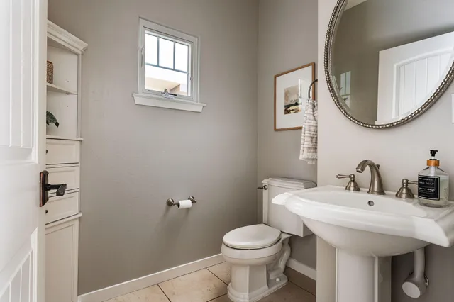a bathroom with a toilet a sink and a mirror