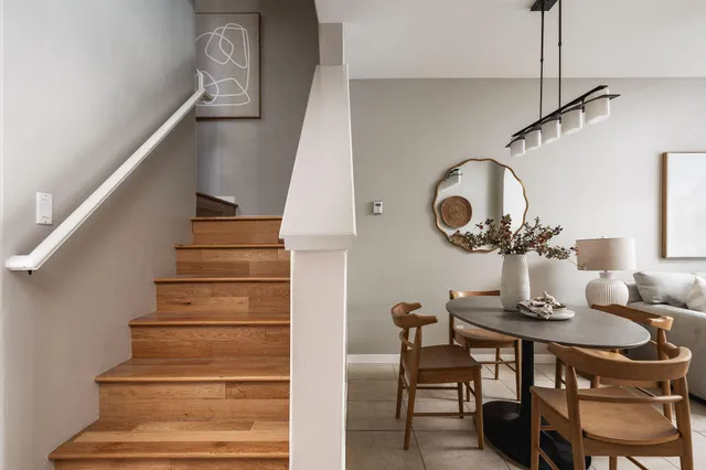 a dining room with wooden floor a chandelier a wooden table and chairs