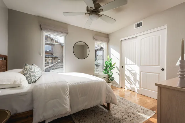 a bedroom with a bed a mirror and a window