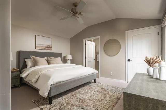 a bedroom with a bed a mirror and lamp