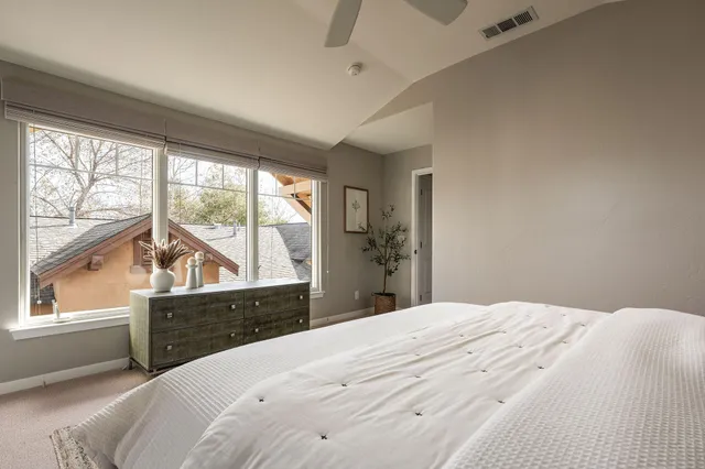a bedroom with a bed and a large window