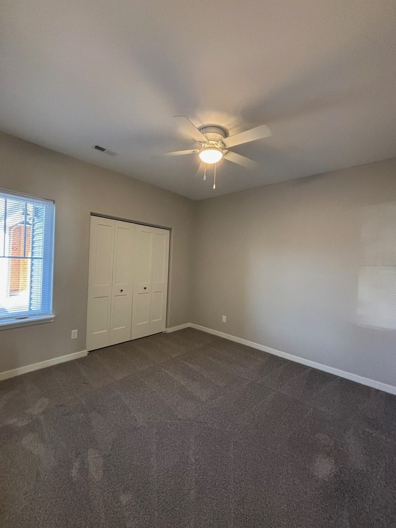 610 Anjali Court, Unit R Sycamore, IL 60178 - Photo 12 of 20 an empty room with a ceiling fan and window