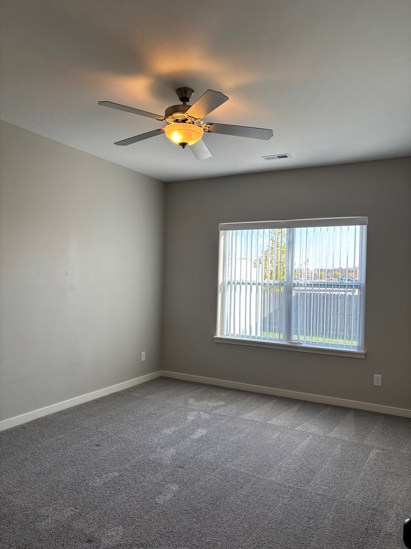 610 Anjali Court, Unit R Sycamore, IL 60178 - Photo 14 of 20 an empty room with a window and a ceiling fan