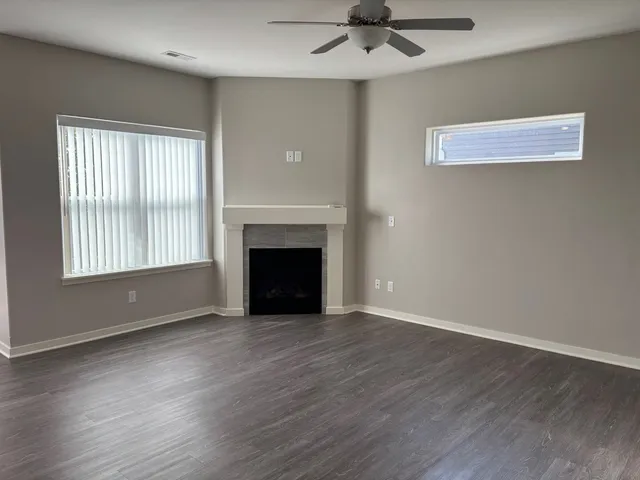 a view of empty room with wooden floor and fireplace