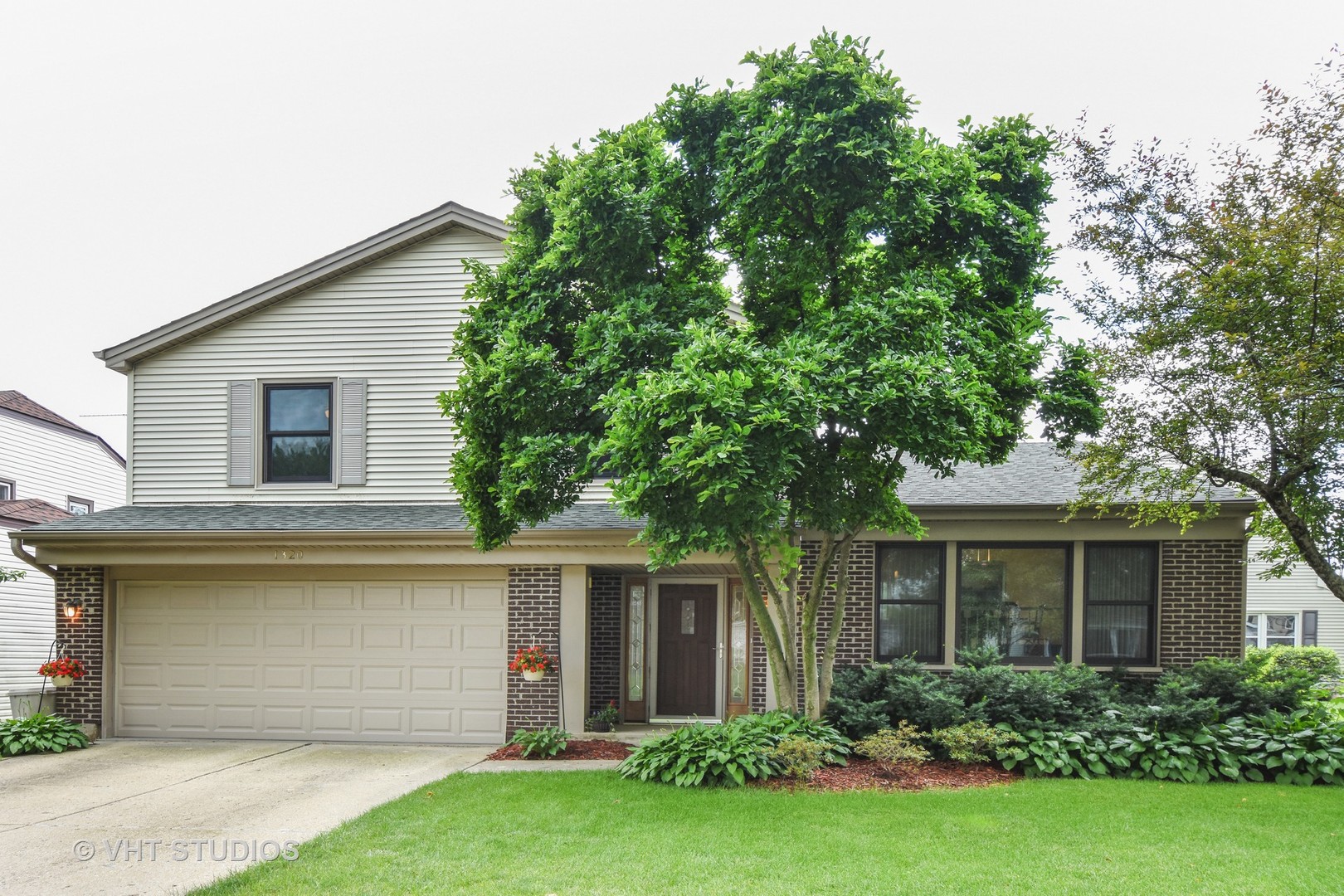 1320 Devonshire Road Buffalo Grove, IL 60089 - Photo 1 of 25 a front view of a house with a garden and yard