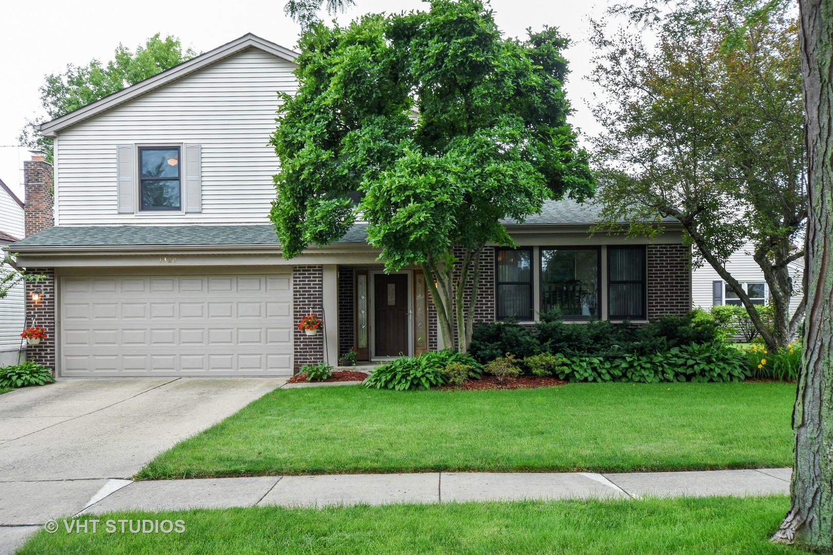 1320 Devonshire Road Buffalo Grove, IL 60089 - Photo 25 of 25 a front view of a house with a garden and yard
