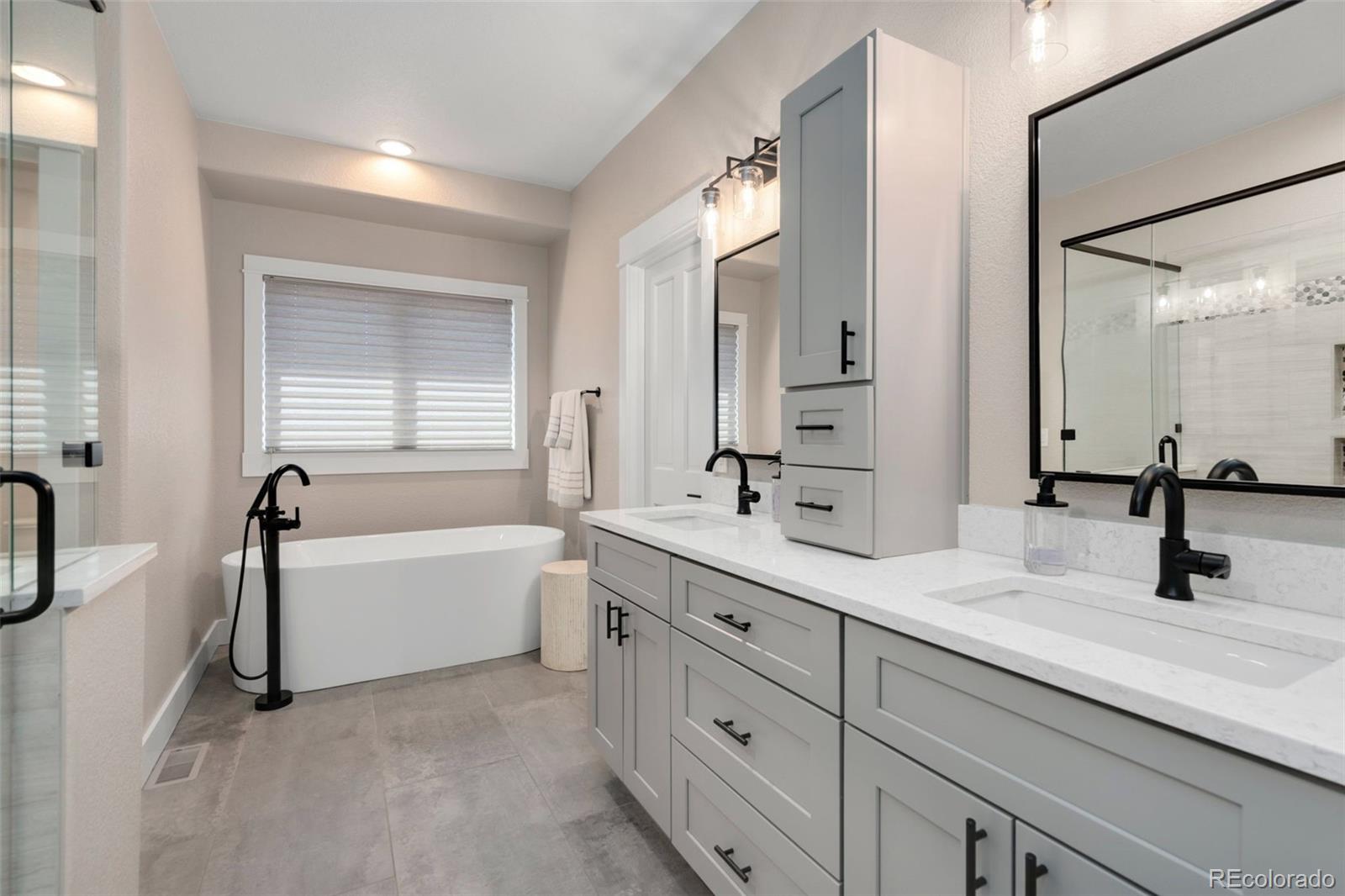5475 Trade Wind Drive Windsor, CO 80528 - Photo 19 of 40 a bathroom with a tub sink double vanity mirror and tub