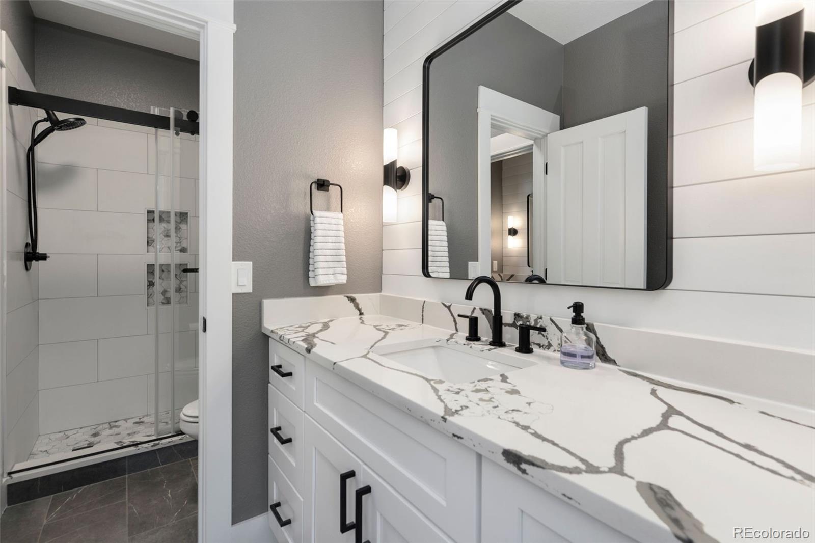 5475 Trade Wind Drive Windsor, CO 80528 - Photo 23 of 40 a bathroom with a double vanity sink mirror and shower