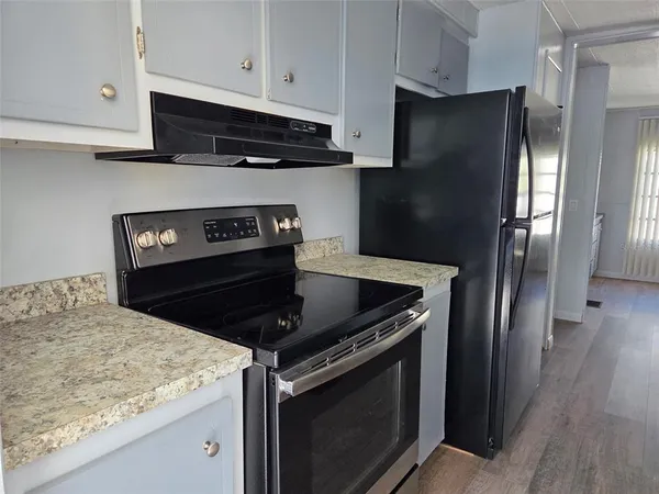 a kitchen with stainless steel appliances granite countertop a refrigerator stove and sink