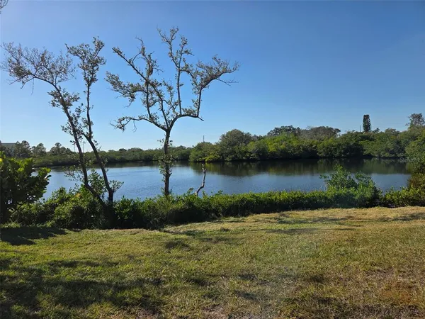 a view of a lake in front of building and trees