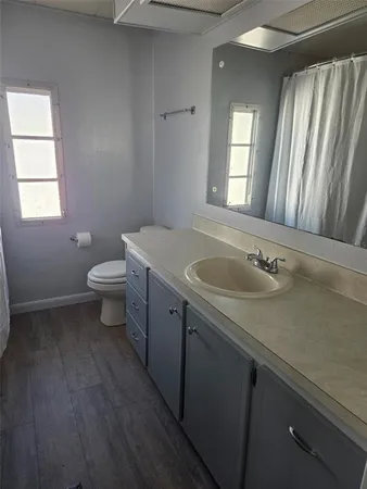 a bathroom with a sink a toilet and a window