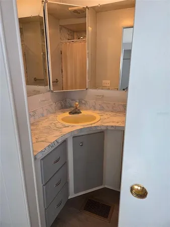 a bathroom with a granite countertop sink and a mirror