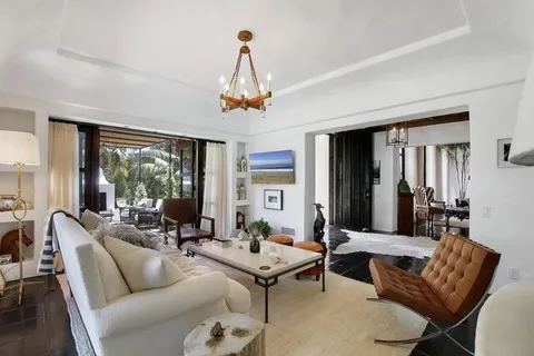 a living room with furniture a large window and a chandelier